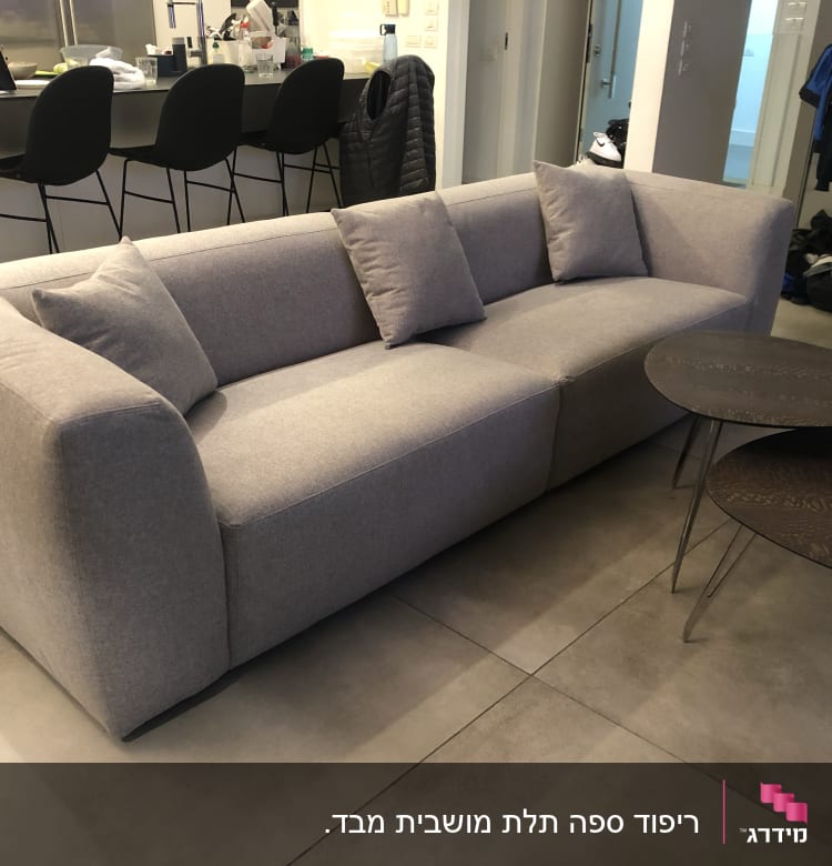 ספה אפורה עם כריות ושולחנות עגולים